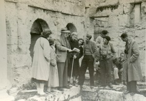 John Caskey explaining the plan of the Spring of Pirene in Corinth; Left to Right: Nancy Ashby, Barbara Hughes, John Caskey, Pam Wiegand, Christine Mitchell, Ruth Allen, Dough Feauer, Bob Held, Mr. Pritchett, Norm Doenges (seated), Mr. Vanderpool; Corinth, 26 Nov. 1951 (photo: Matthew Wiencke)